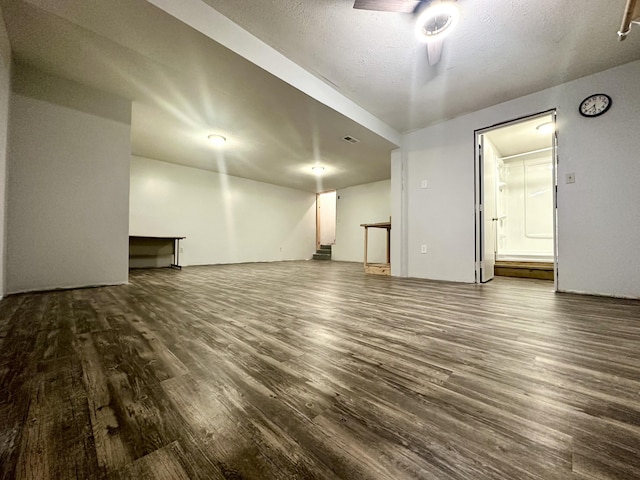 interior space featuring a textured ceiling and dark wood-type flooring