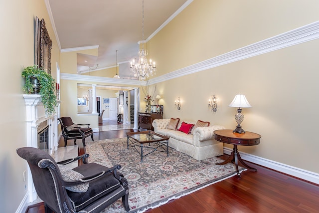 living room with an inviting chandelier, high vaulted ceiling, wood-type flooring, and ornamental molding