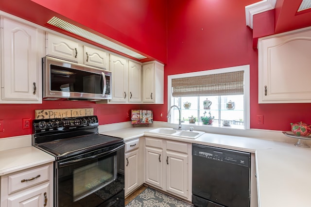 kitchen with sink, white cabinetry, and black appliances