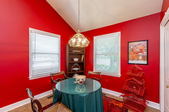 tiled dining area featuring built in shelves, a chandelier, and lofted ceiling