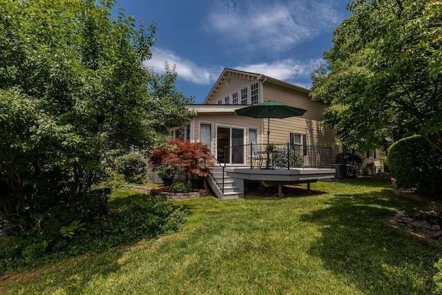 rear view of house with a yard and a deck