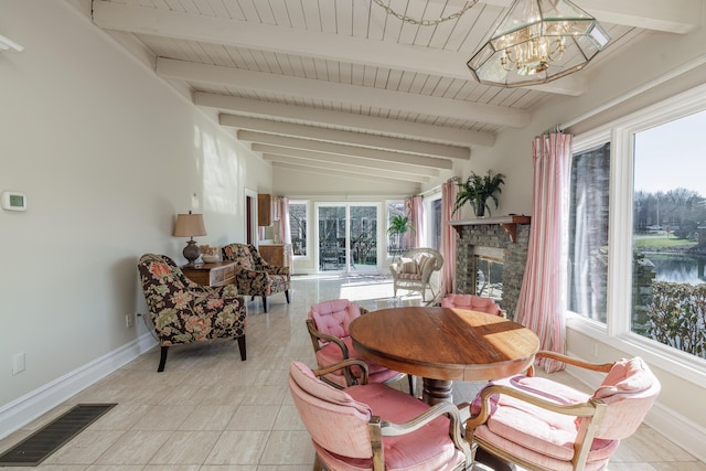 dining area featuring a stone fireplace, vaulted ceiling with beams, wood ceiling, light tile patterned floors, and a notable chandelier