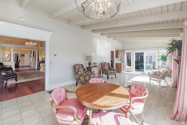 dining space featuring vaulted ceiling with beams, decorative columns, and a notable chandelier