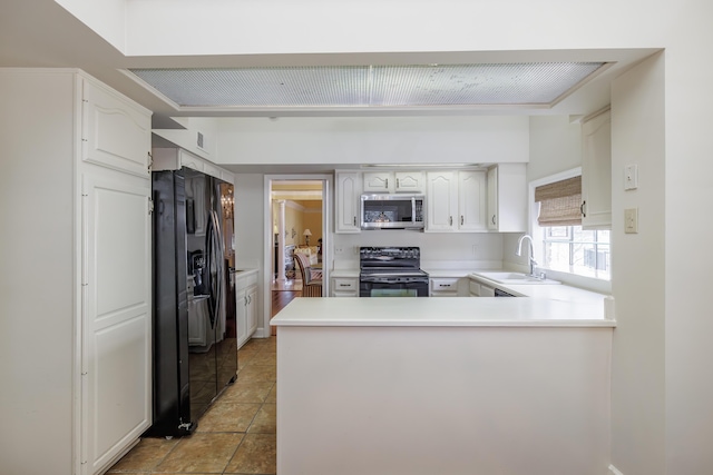 kitchen with sink, white cabinetry, light tile patterned floors, kitchen peninsula, and black appliances