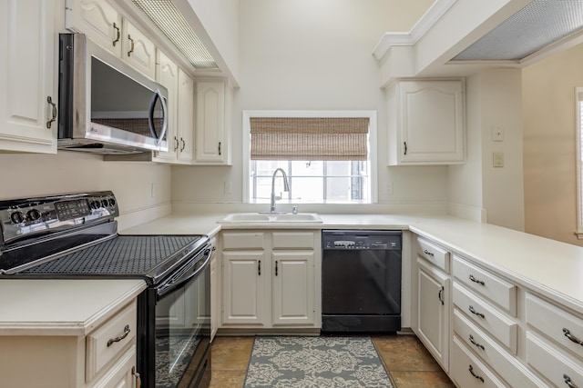 kitchen featuring sink, kitchen peninsula, white cabinets, and black appliances