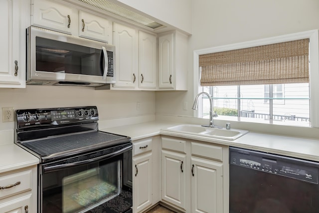 kitchen with sink, black appliances, and white cabinets