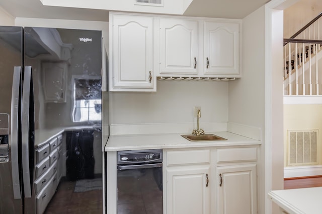 kitchen with white cabinetry, sink, and black fridge with ice dispenser