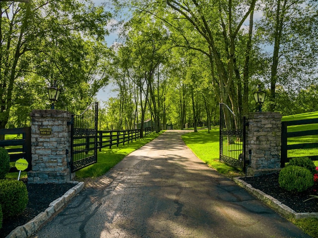 view of gate with a fenced front yard and a lawn