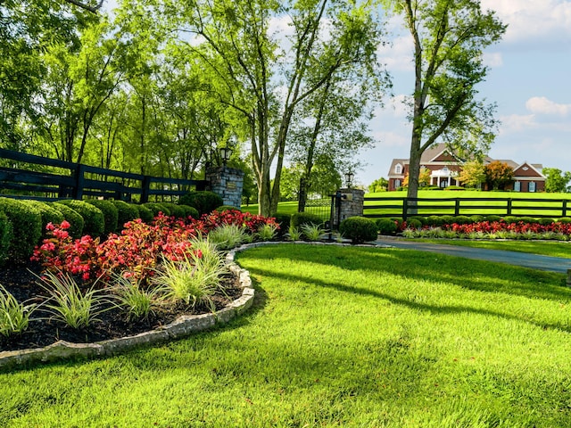 view of property's community featuring a fenced front yard and a lawn