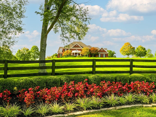 view of home's community featuring a lawn and fence