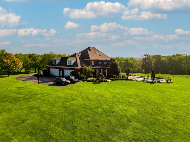 rear view of house with a lawn, an attached garage, and fence