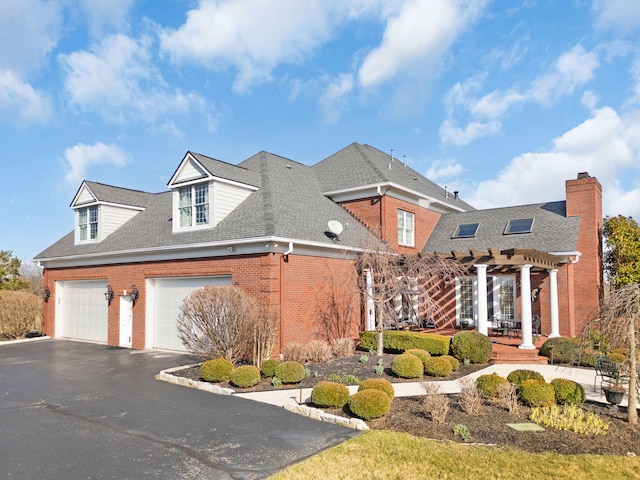 view of front of home featuring roof with shingles, a pergola, a garage, aphalt driveway, and brick siding