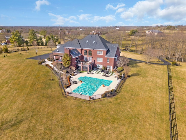 view of pool with a yard, a patio, a rural view, and fence