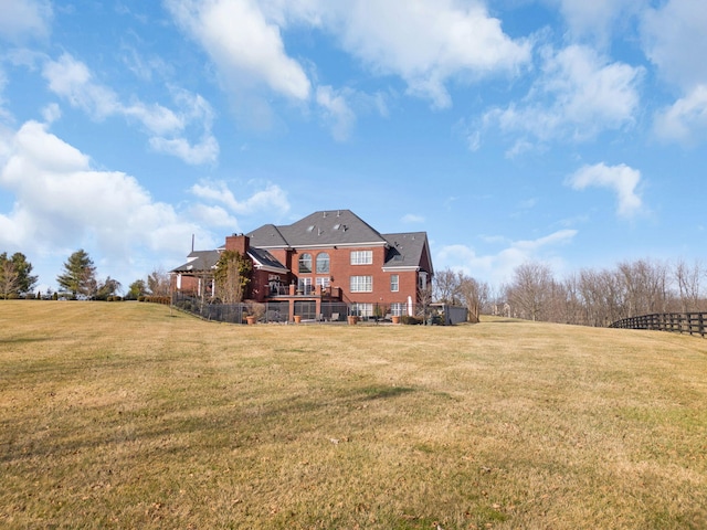 rear view of house featuring a wooden deck and a yard