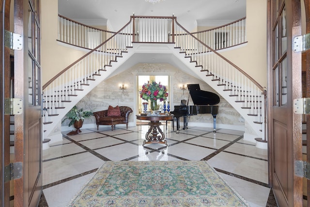 entrance foyer featuring a high ceiling, stairway, and baseboards