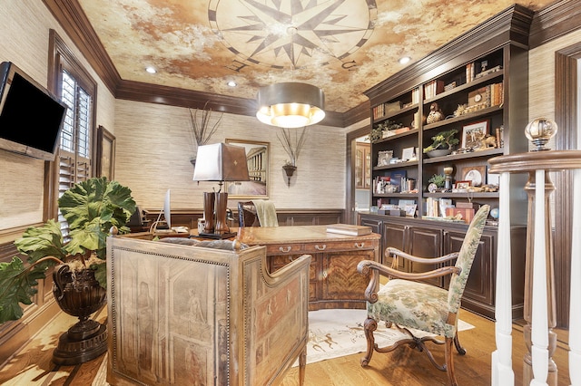 office area featuring wallpapered walls, crown molding, light wood-style floors, and a wainscoted wall