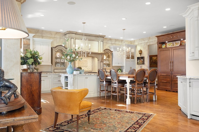 dining space featuring recessed lighting, light wood-style floors, and a notable chandelier