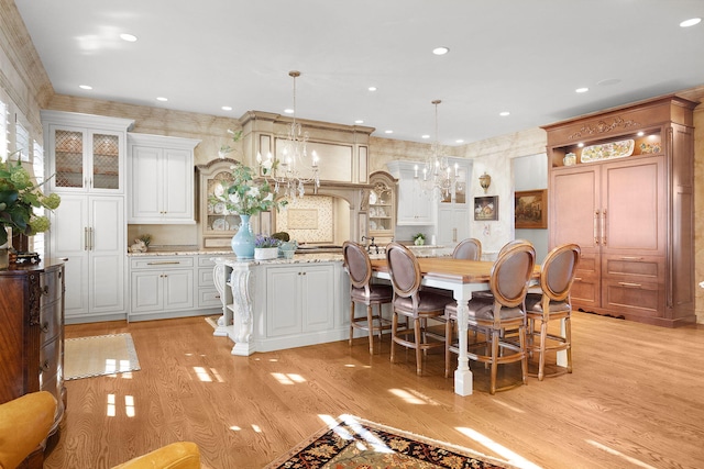 kitchen with open shelves, glass insert cabinets, a large island, and light wood-type flooring