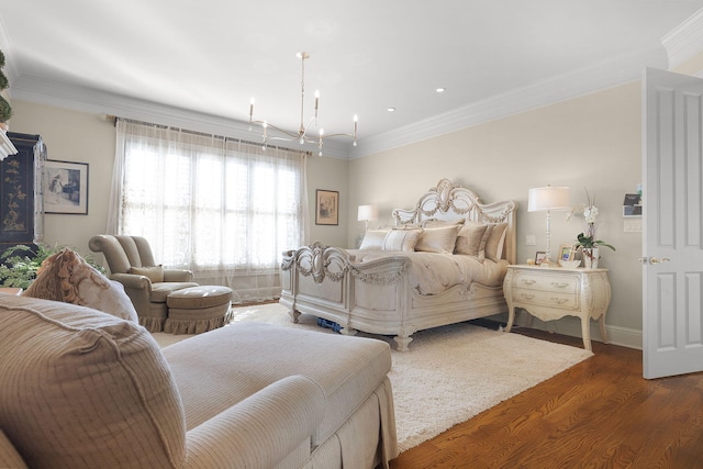 bedroom featuring baseboards, a notable chandelier, wood finished floors, and crown molding