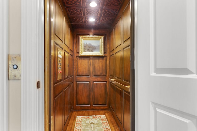 interior details with an ornate ceiling, elevator, and wood finished floors