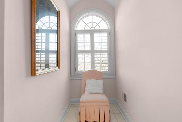 sitting room with tile patterned flooring, plenty of natural light, baseboards, and vaulted ceiling