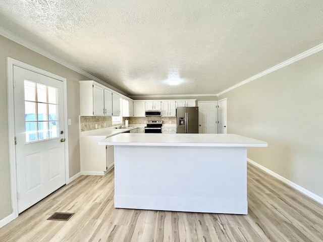 kitchen featuring sink, light hardwood / wood-style flooring, white cabinetry, backsplash, and stainless steel appliances