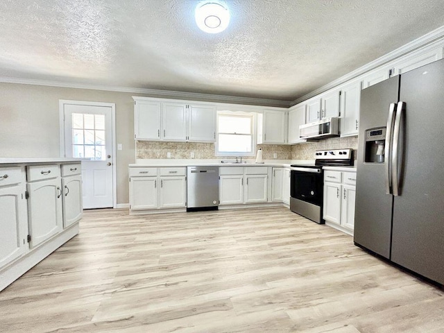 kitchen featuring sink, crown molding, light hardwood / wood-style flooring, appliances with stainless steel finishes, and white cabinets