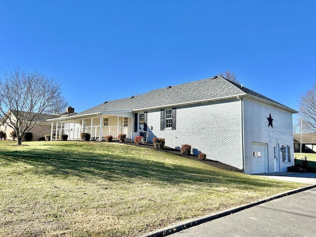 rear view of house featuring a garage, a yard, and covered porch