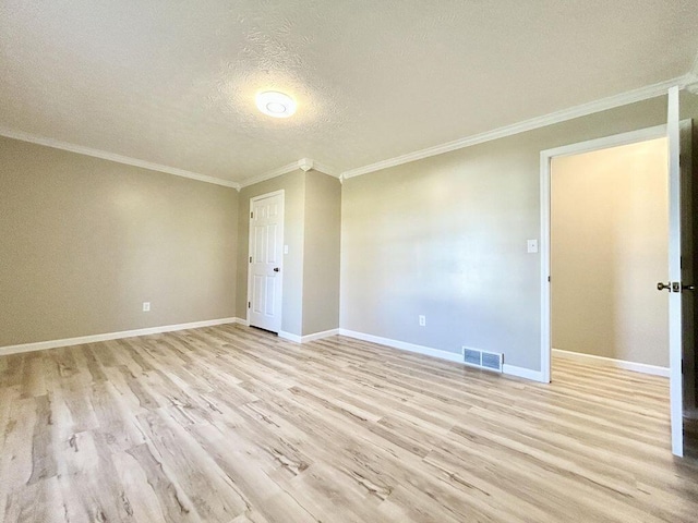 empty room with ornamental molding, light wood-type flooring, and a textured ceiling