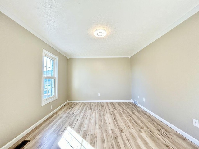 unfurnished room with ornamental molding, light wood-type flooring, and a textured ceiling