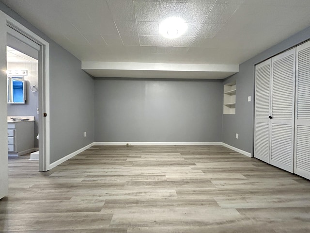 unfurnished bedroom with ensuite bath, light hardwood / wood-style flooring, and a closet