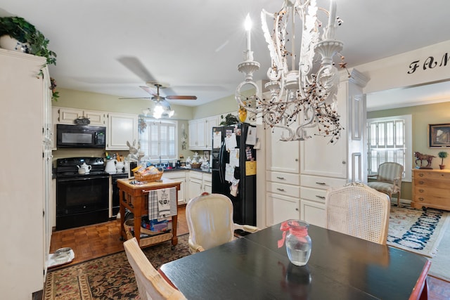 dining space with ceiling fan with notable chandelier and dark parquet flooring