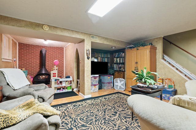 living room with a wood stove and light hardwood / wood-style floors