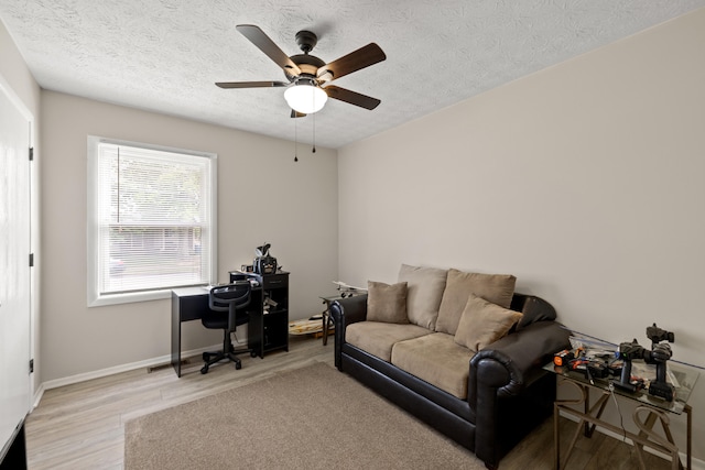 office featuring light hardwood / wood-style floors, a textured ceiling, and ceiling fan