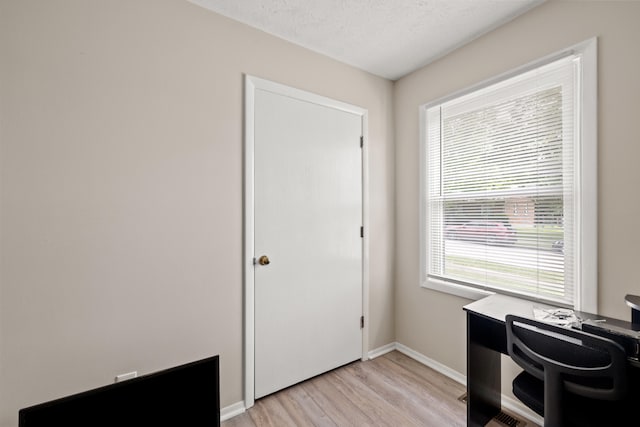 office with light hardwood / wood-style flooring and a textured ceiling