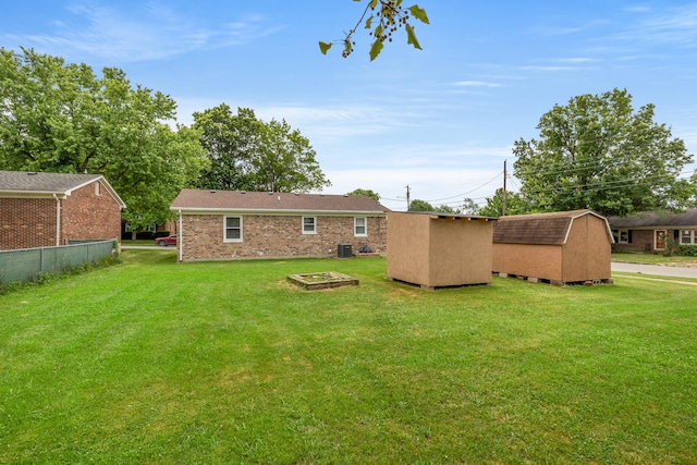 view of yard with a shed and an outdoor fire pit