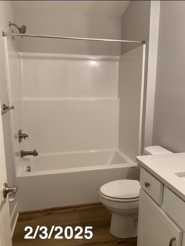 full bathroom with toilet, wood-type flooring, shower / washtub combination, and vanity