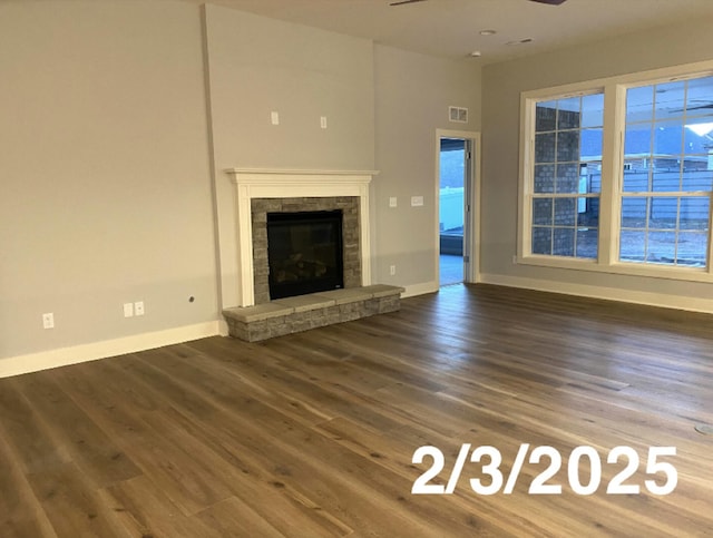 unfurnished living room with dark wood-type flooring, a fireplace, and ceiling fan