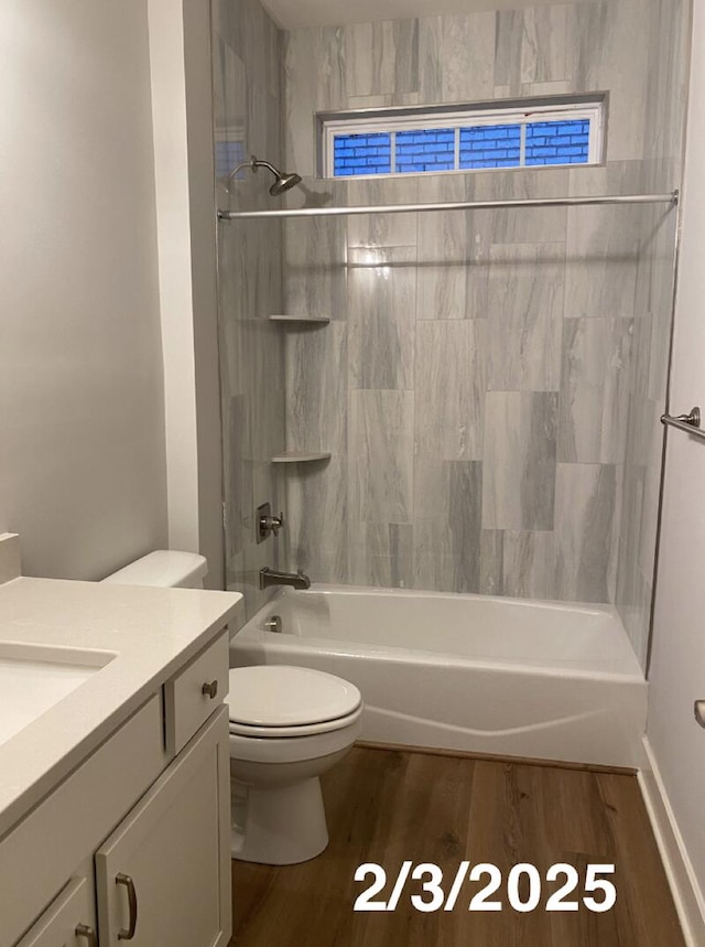 full bathroom with vanity, hardwood / wood-style flooring, toilet, and tiled shower / bath combo