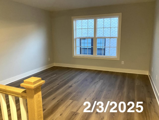 unfurnished room with dark wood-type flooring