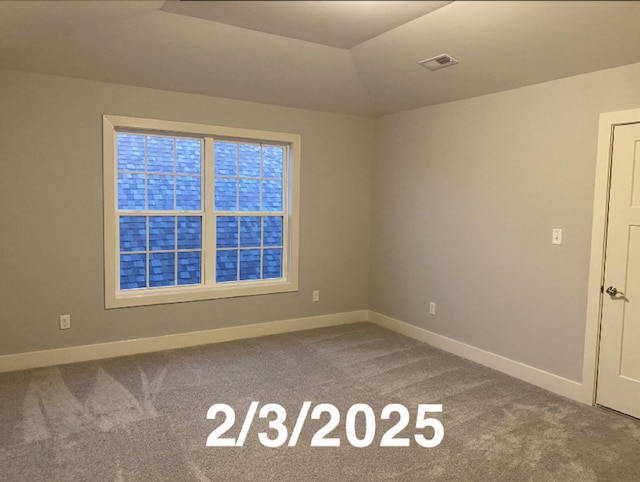 spare room featuring vaulted ceiling and carpet floors