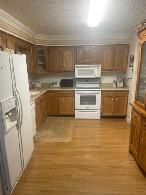 kitchen with a textured ceiling, white appliances, light hardwood / wood-style floors, and ornamental molding