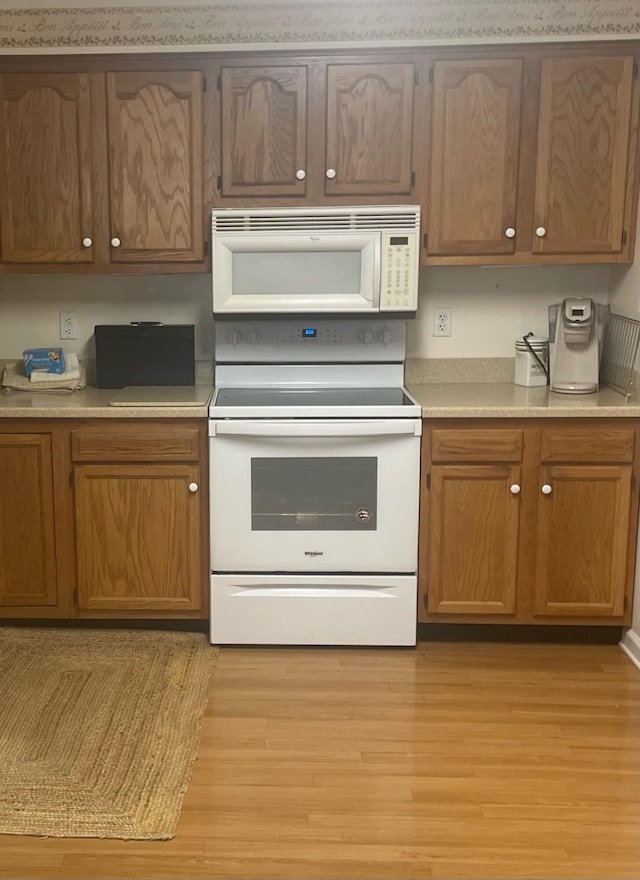 kitchen featuring white appliances and light hardwood / wood-style flooring