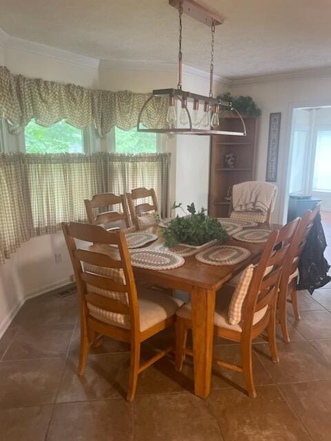 tiled dining area with ornamental molding and a chandelier