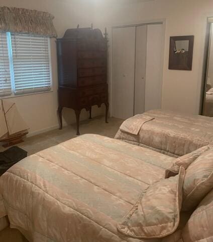 bedroom featuring light colored carpet and a closet