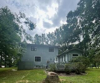 rear view of house with a yard and a wooden deck