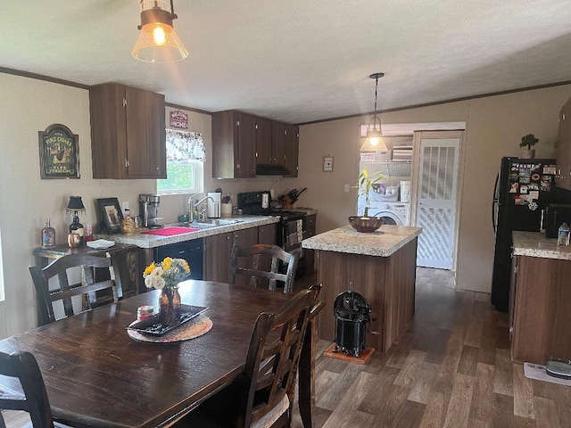 dining room with a textured ceiling, dark hardwood / wood-style flooring, crown molding, and sink