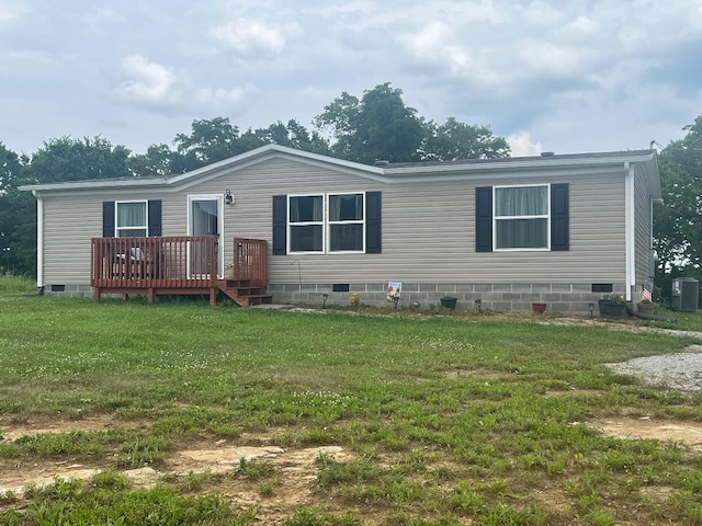 manufactured / mobile home featuring a wooden deck, a front lawn, and central AC unit