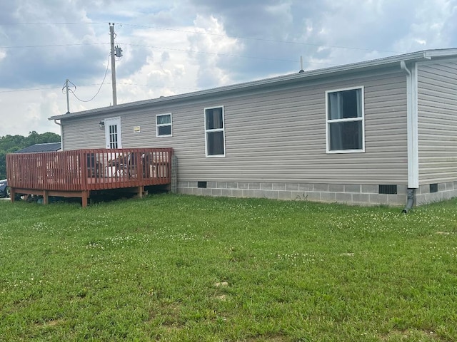 back of property with a lawn and a deck