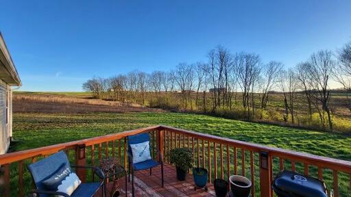 wooden terrace featuring a yard, a rural view, and grilling area